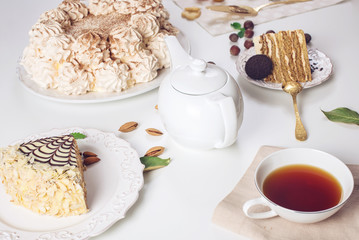 Decorated dessert table where the cake with meringue, layered pieces of cake. Arrangement of delicious sweets, top view