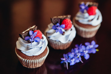 Beautiful and tasty muffins with raspberries and flowers