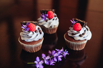 Beautiful and tasty muffins with raspberries and flowers