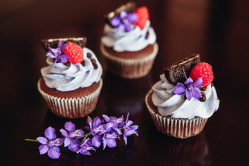 Beautiful and tasty muffins with raspberries and flowers