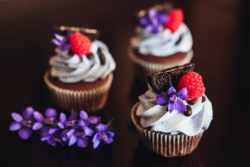 Beautiful and tasty muffins with raspberries and flowers