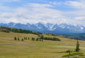 Scenic view of Kurai steppe andwhite  peaks of North-Chiyski ridge in Altai mountains in overcast weather. Altay Republic, Siberia, Russia.