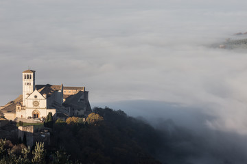 Beautiful view of St.Francis church in Assisi, over a sea of fog