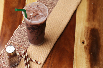 Ice cocoa soft drink on wood floor and topping