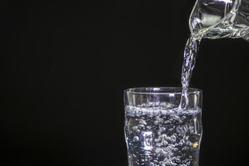 Pour drinking water on a black background.