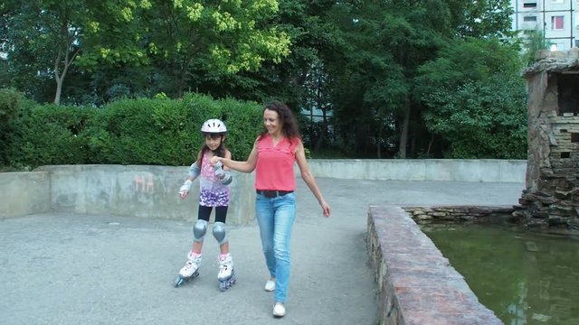 The child learns to skate. Mom teaches the child to skate.