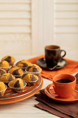 Coffee with muffins on a light wooden background.
