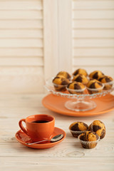 Coffee with muffins on a light wooden background.