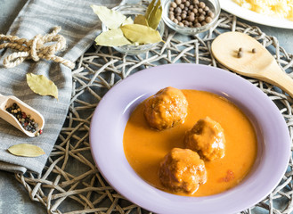 Meat balls of beef in tomato sauce served on a purple plate. As an addition to pasta