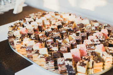 Delicious and tasty dessert table with cupcakes shots at reception closeup