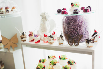 Delicious sweets on wedding candy buffet with desserts, cupcakes