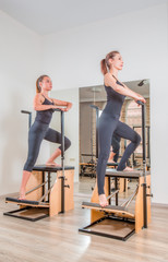 Young women exercising on pilates combo wunda pilates chair