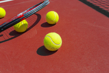 Tennis balls and racket on the grass court