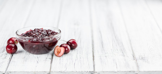 Wooden table with Cherry Jam, selective focus