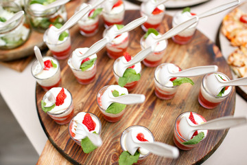 Pink coloured strawberry dessert in shot glass, catering buffet