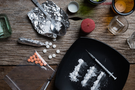 alcohol, drugs, pills on a wood background
