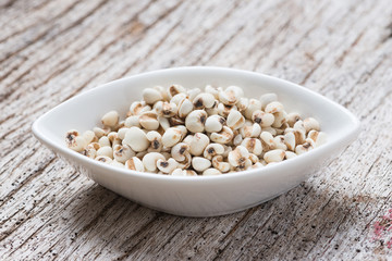 Job's tears in bowl on rustic wooden table