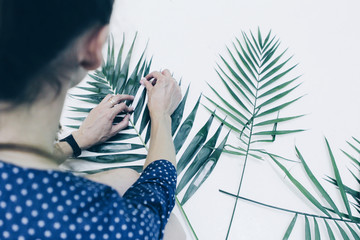 Girl works, hands, tropical leaves and white background