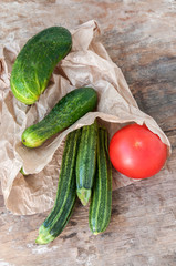 Tomato, zucchini and cucumber in paper bag on the table
