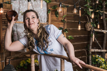 Ugly woman in national dress posing in a rustic interior