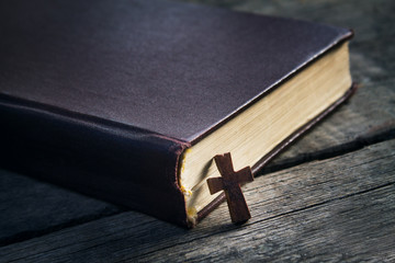 Cross and Bible on a wood background.