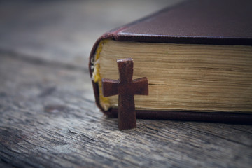 Cross and Bible on a wood background.