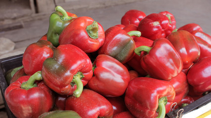 Heap of fresh red bell peppers in morning market