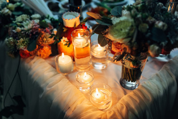 Shiny candles stand on the dinner table