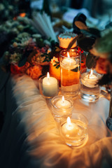 Shiny candles stand on the dinner table