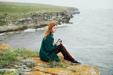 Beautiful young woman on a cliff of a mountain near the sea