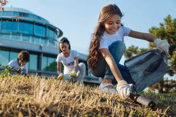 Delighted little girl working in volunteer group