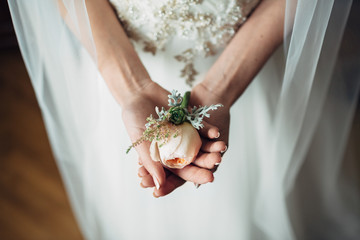 Obraz premium Bride holds tender boutonniere in her arms