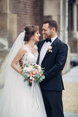 Classy wedding couple poses on the old European street