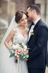 Classy wedding couple poses on the old European street