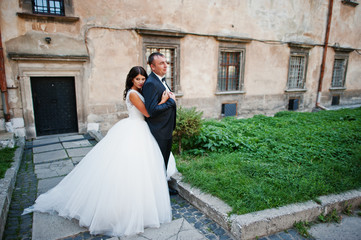Amazing young attractive newly married couple walking and posing in the downtown with beautiful and...