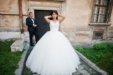 Amazing young attractive newly married couple walking and posing in the downtown with beautiful and...