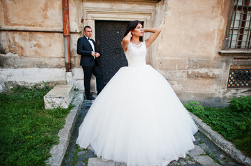 Amazing young attractive newly married couple walking and posing in the downtown with beautiful and...