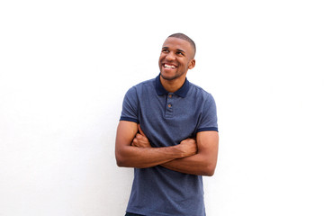 Cheerful black guy with arms crossed and looking away against white background