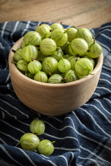 Fresh gooseberry in a wooden bowl.
