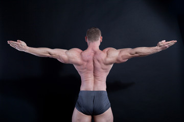 Naklejka premium the athlete bodybuilder shows his muscles after sports