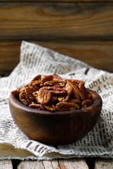a pecan is in a wooden bowl. style rustic