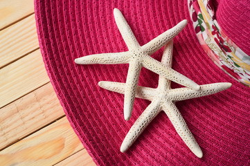 Fototapeta na wymiar Summer straw hat and starfish on wooden background