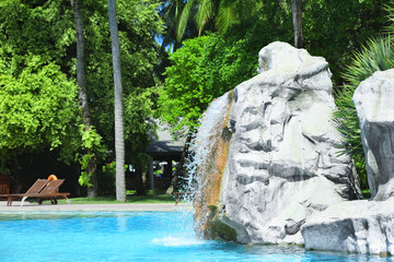 Artificial waterfall in beach hotel on summer day