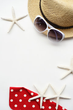 Summer hat and sunglasses with accessories and sandals on white background