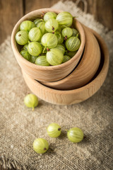 Fresh gooseberry in a wooden bowl.