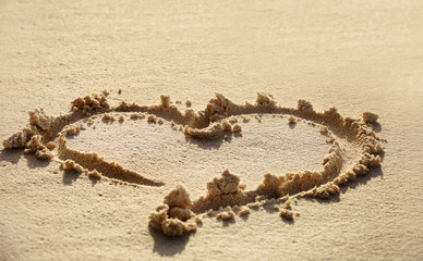 Drawing of heart on beach sand. Summer vacation concept
