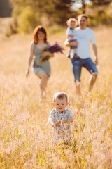 Parents walks with their children on sunny field