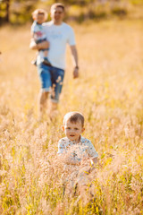 Fototapeta premium Parents walks with their children on sunny field
