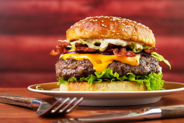Bacon cheese burger on plate with homemade brioche bun  , red wooden log background - 165536481