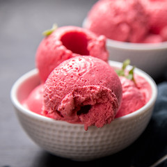 Ice cream Raspberry  in white bowl on the black background.Dessert.Copy space for Text.Sorbet In the form of a ball.selective focus.